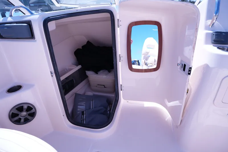 Slide: The Image of 2019 Grady-White Freedom 215 boat interior with open storage compartment and mirror. - 26