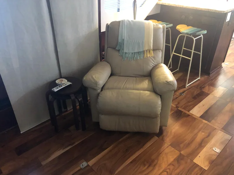 Slide: The Image of Beige recliner chair with a throw blanket, next to a small table in a 1990 Bluewater Sedan. - 17