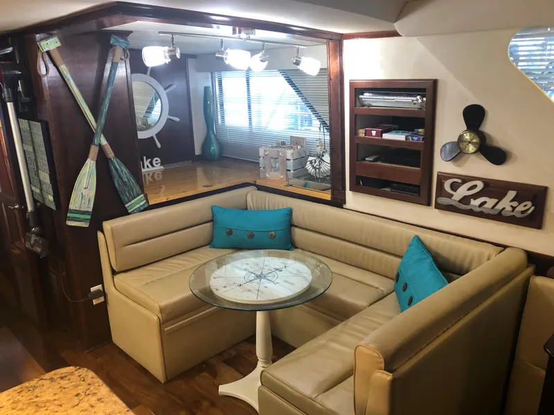 Slide: The Image of 1990 Bluewater Sedan interior with cozy seating, nautical decor, and a round table. - 23