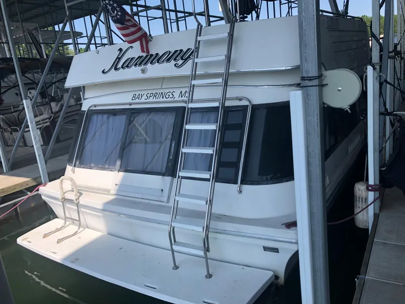 Slide: The Image of 1990 Bluewater Sedan boat docked with ladder and American flag. - 3