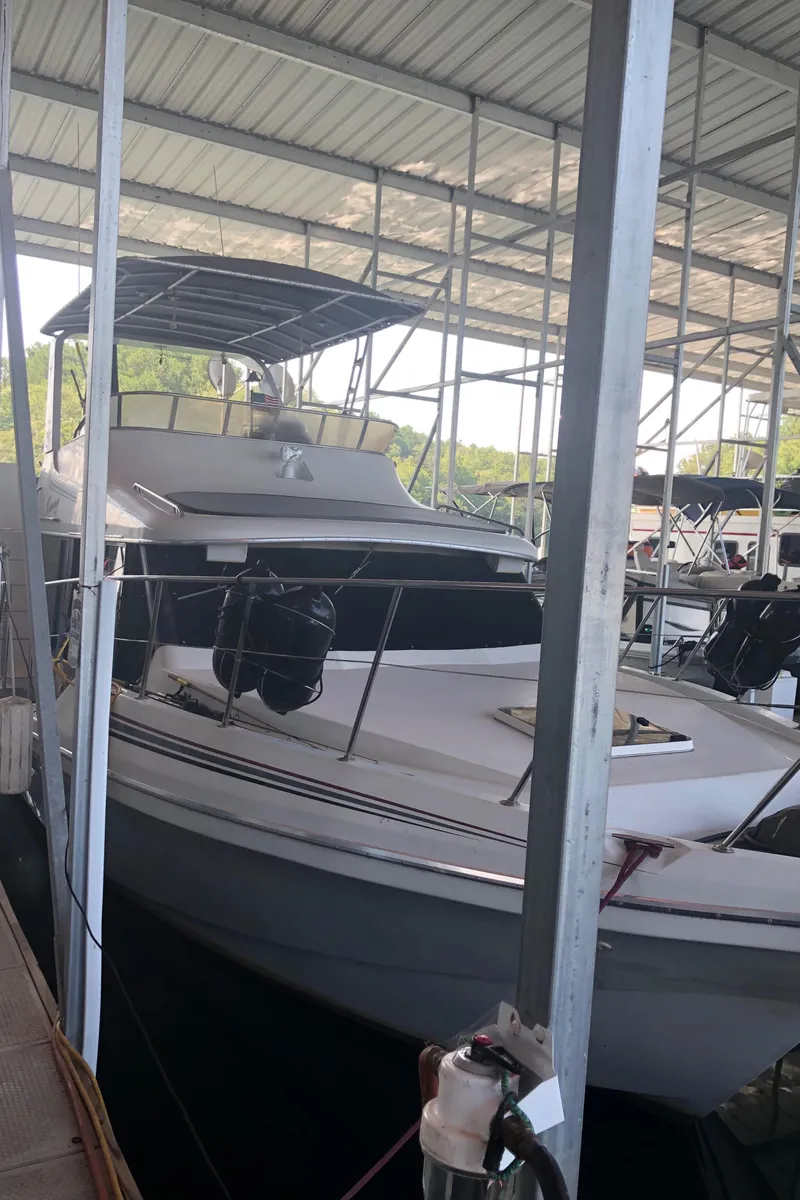 Slide: The Image of 1990 Bluewater Sedan boat docked in a covered marina. - 7