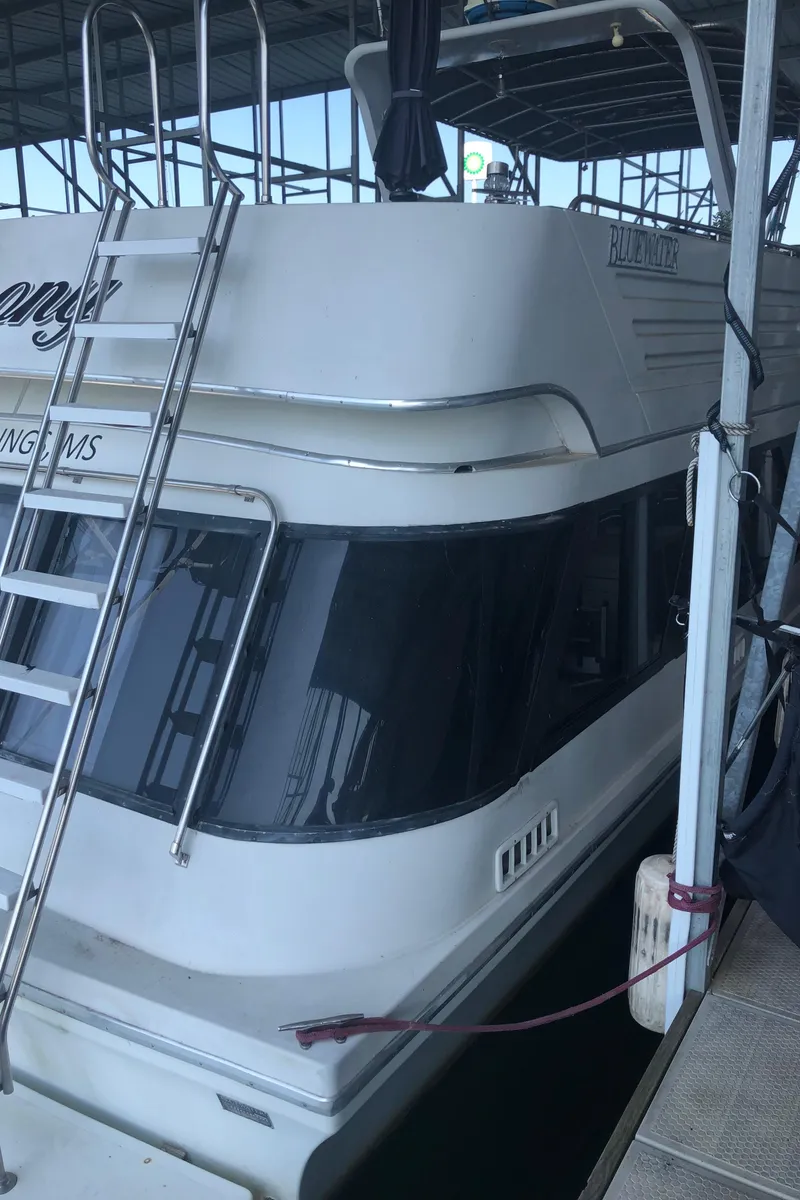 Slide: The Image of 1990 Bluewater Sedan boat docked in a marina. - 8