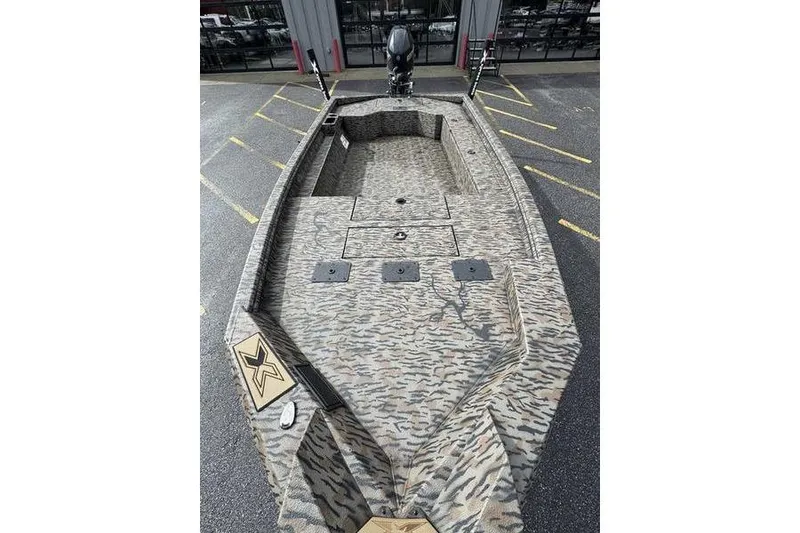 Slide: The Image of 2026 Xpress X18DB boat with camouflage design, parked in a lot. - 10