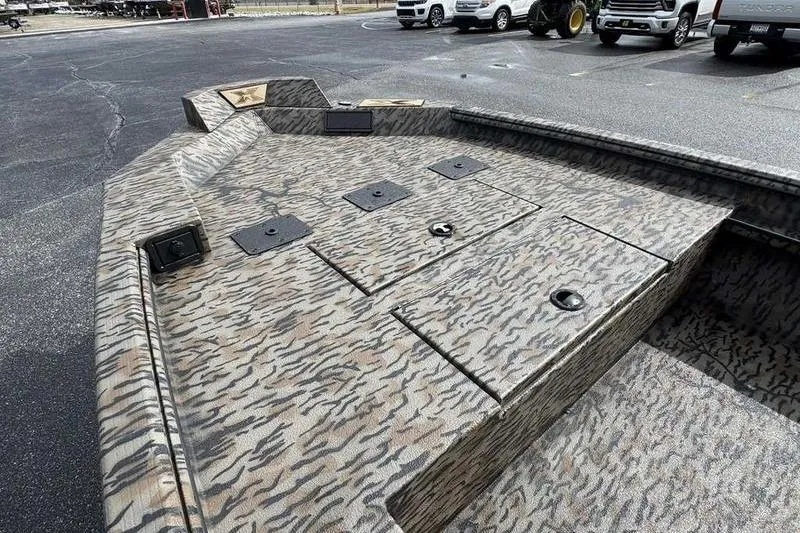 Slide: The Image of 2026 Xpress X18DB boat with camouflage deck pattern in a parking lot. - 13