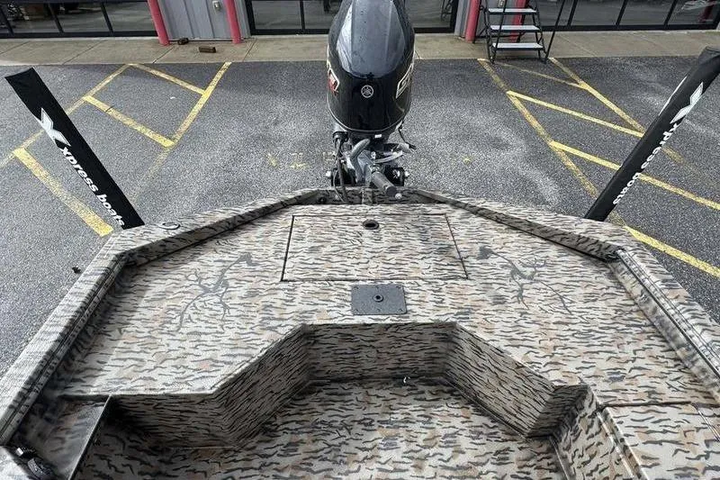 Slide: The Image of 2026 Xpress X18DB boat with camouflage deck and outboard motor in parking lot. - 17