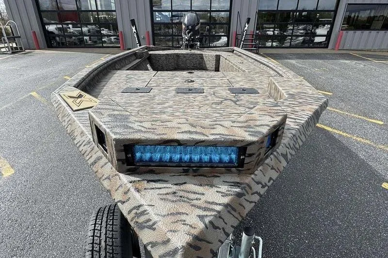 Slide: The Image of 2026 Xpress X18DB boat with camouflage design and blue LED light bar. - 3