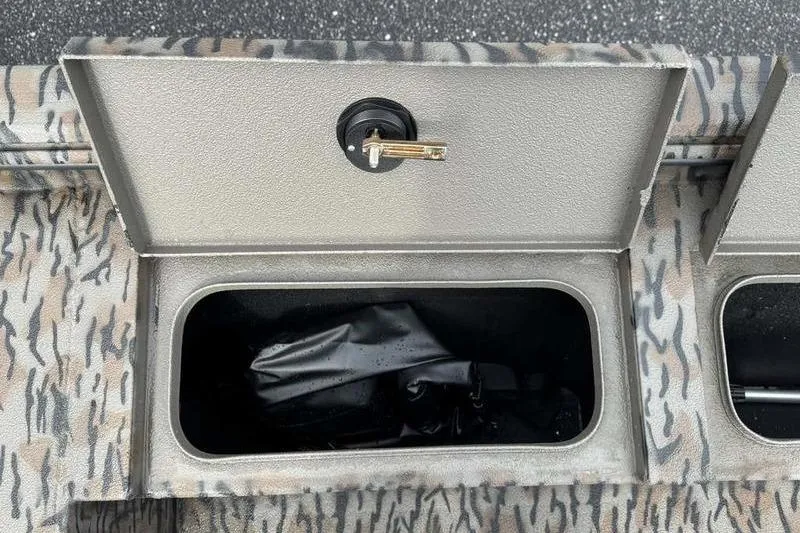 Slide: The Image of Open storage compartment on 2026 Xpress X18DB boat with camouflage pattern. - 9
