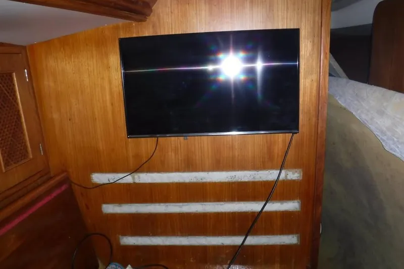 Slide: The Image of Interior of 1986 Fast Masthead Sloop with mounted TV on wooden wall. - 15