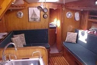 Slide: The Image of 1986 Fast Masthead Sloop interior with wood finish and cozy seating area. - 16