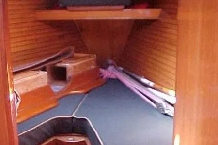 Slide: The Image of 1986 Fast Masthead Sloop interior cabin with wooden finish and storage space. - 19