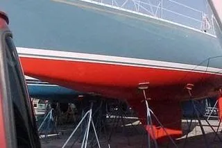Slide: The Image of 1986 Fast Masthead Sloop with Bowthruster on stands, blue hull, red keel. - 3