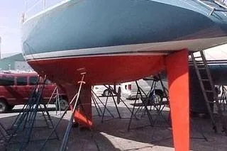 Slide: The Image of 1986 Fast Masthead Sloop sailboat with bowthruster, displayed on stands in a boatyard. - 4