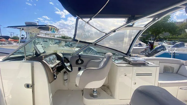 Slide: The Image of 2011 Sea Ray 300 Sundeck boat interior with helm, seating, and canopy. - 10