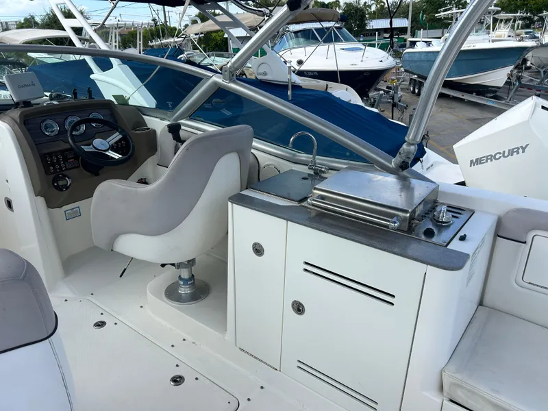 Slide: The Image of 2011 Sea Ray 300 Sundeck interior with helm, seating, and outdoor kitchen area. - 17