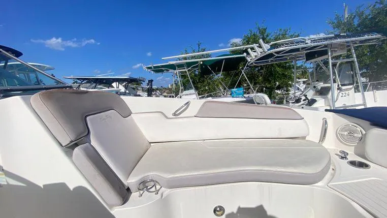 Slide: The Image of 2011 Sea Ray 300 Sundeck boat interior with cushioned seating under clear blue sky. - 21