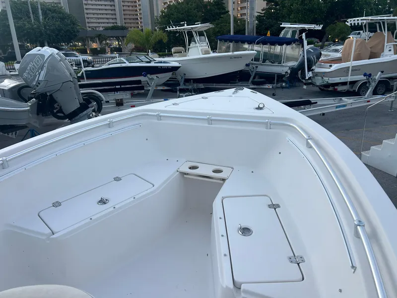 Slide: The Image of 2009 Cobia 216 Center Console boat docked with other vessels in a marina. - 9