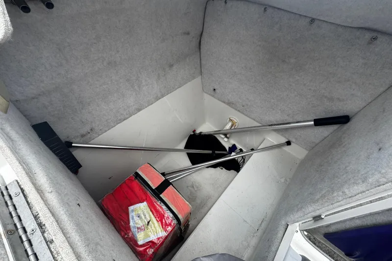 Slide: The Image of Storage compartment of 2008 Splendor 240 Sunstar boat with cleaning tools and red bag. - 10