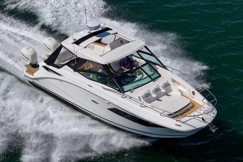 Slide: The Image of 2021 Sea Ray Sundancer 320 Outboard cruising on open water, showcasing sleek design and powerful engines. - 10