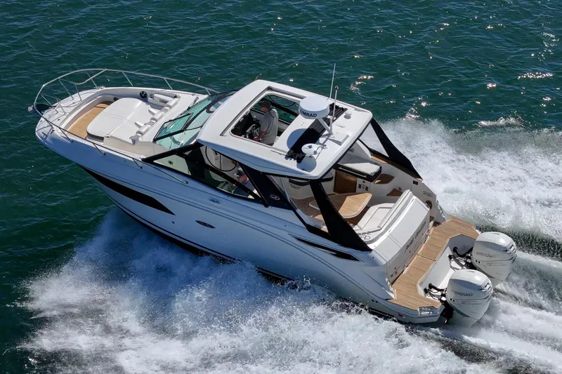 Slide: The Image of 2021 Sea Ray Sundancer 320 Outboard cruising on open water, showcasing sleek design and powerful engines. - 15