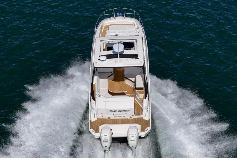 Slide: The Image of 2021 Sea Ray Sundancer 320 Outboard cruising on open water, rear view. - 23