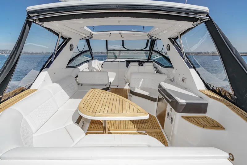 Slide: The Image of 2021 Sea Ray Sundancer 320 Outboard interior with elegant seating and wooden table. - 24