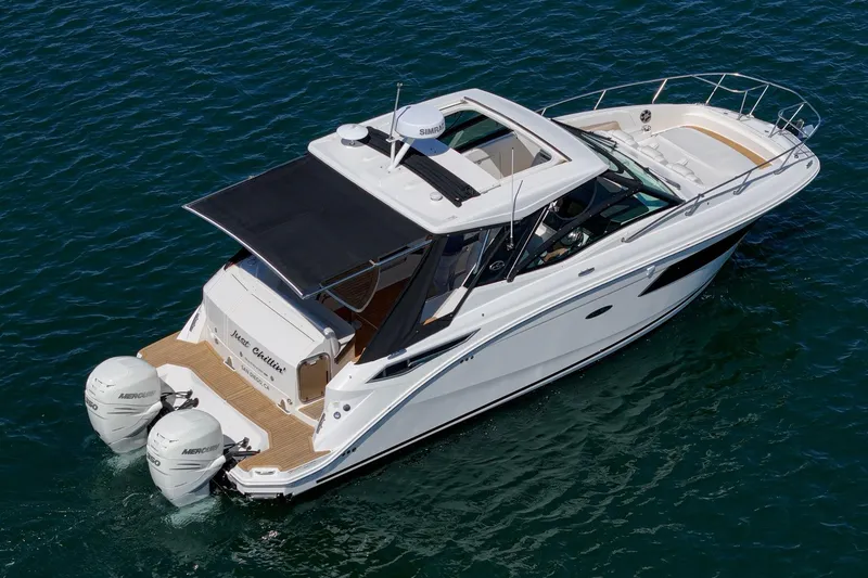 Slide: The Image of 2021 Sea Ray Sundancer 320 Outboard cruising on clear blue water. - 26