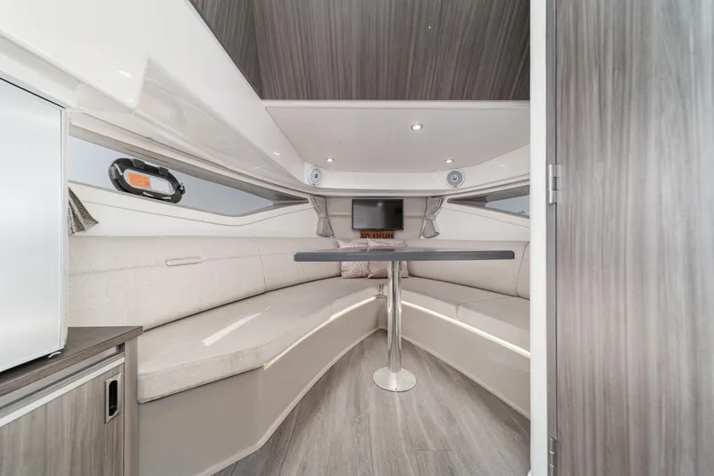 Slide: The Image of 2021 Sea Ray Sundancer 320 Outboard cabin interior with modern seating and table. - 46