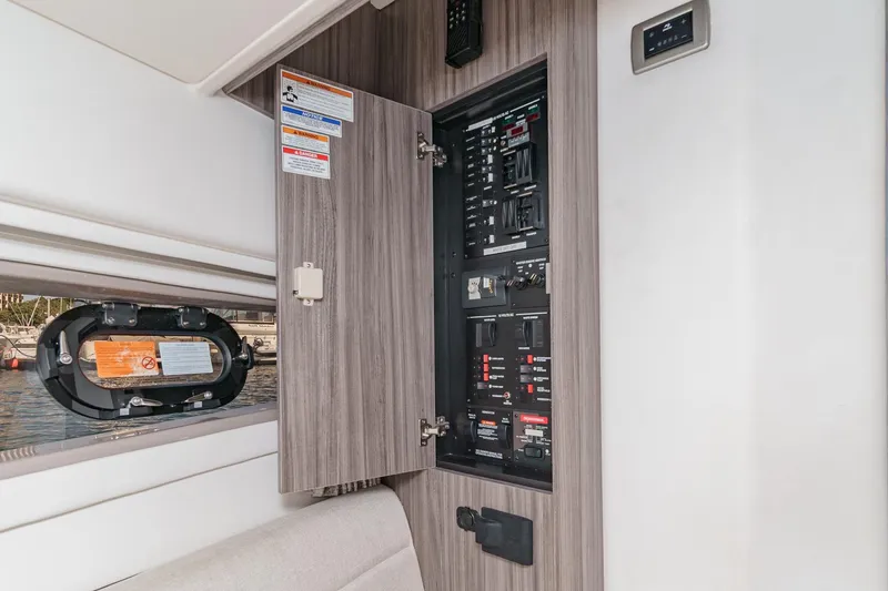 Slide: The Image of 2021 Sea Ray Sundancer 320 Outboard electrical panel with open cabinet door. - 51