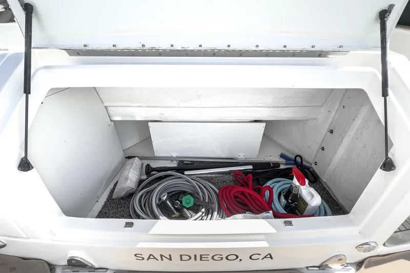 Slide: The Image of Storage compartment of 2021 Sea Ray Sundancer 320 Outboard with cleaning supplies and ropes. - 57