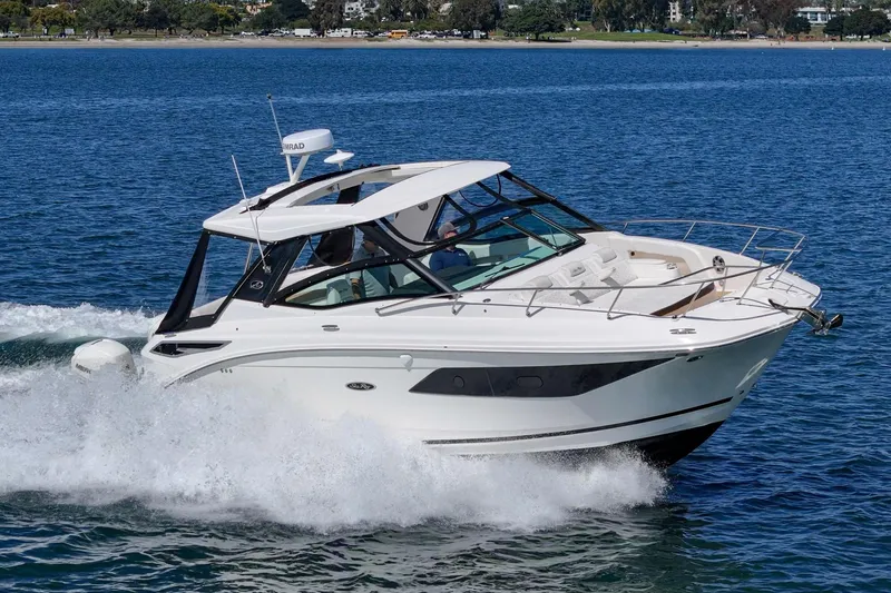 Slide: The Image of 2021 Sea Ray Sundancer 320 Outboard cruising on blue water, showcasing sleek design and performance. - 9