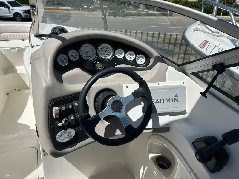 Slide: The Image of 2003 Stingray 240 LR boat dashboard with Garmin navigation system and steering wheel. - 10