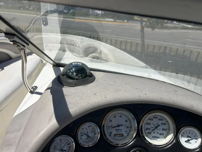Slide: The Image of Dashboard of a 2003 Stingray 240 LR boat with compass and gauges. - 14