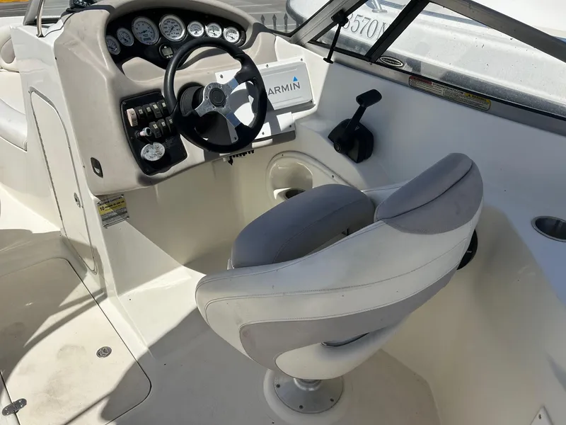 Slide: The Image of 2003 Stingray 240 LR boat cockpit with steering wheel and control panel. - 15