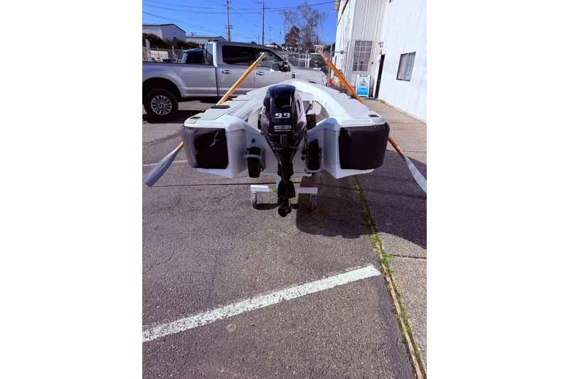 Slide: The Image of OC Tenders OC-300 boat, 2020 model, with outboard motor, parked outdoors. - 19