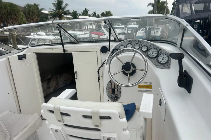 Slide: The Image of 2001 Sea Fox 204 Millenium boat cockpit with steering wheel and gauges, docked near palm trees. - 4