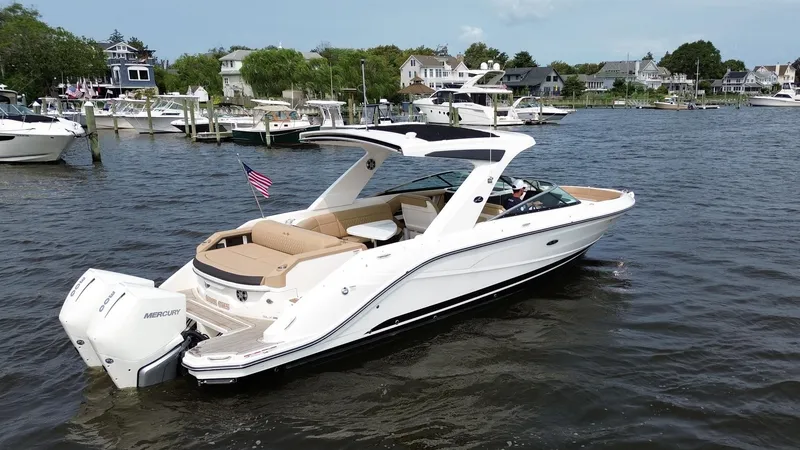 Slide: The Image of 2023 Sea Ray SLX 310 boat on water, featuring sleek design and spacious seating. - 1