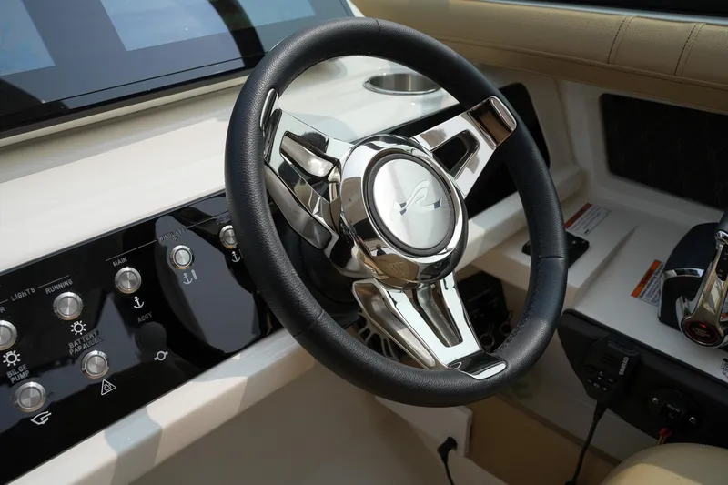 Slide: The Image of 2023 Sea Ray SLX 310 steering wheel and dashboard controls. - 12