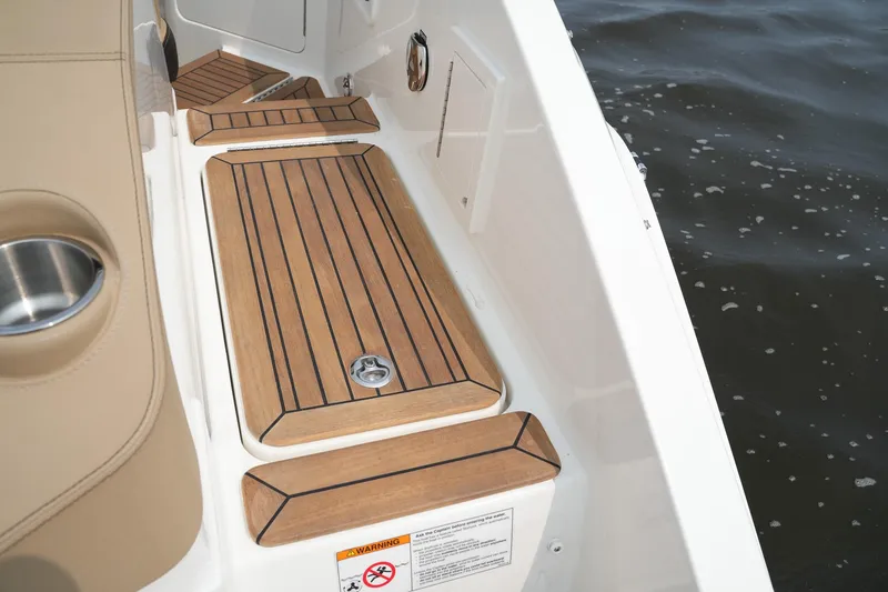 Slide: The Image of 2023 Sea Ray SLX 310 boat deck with teak flooring by the water. - 28