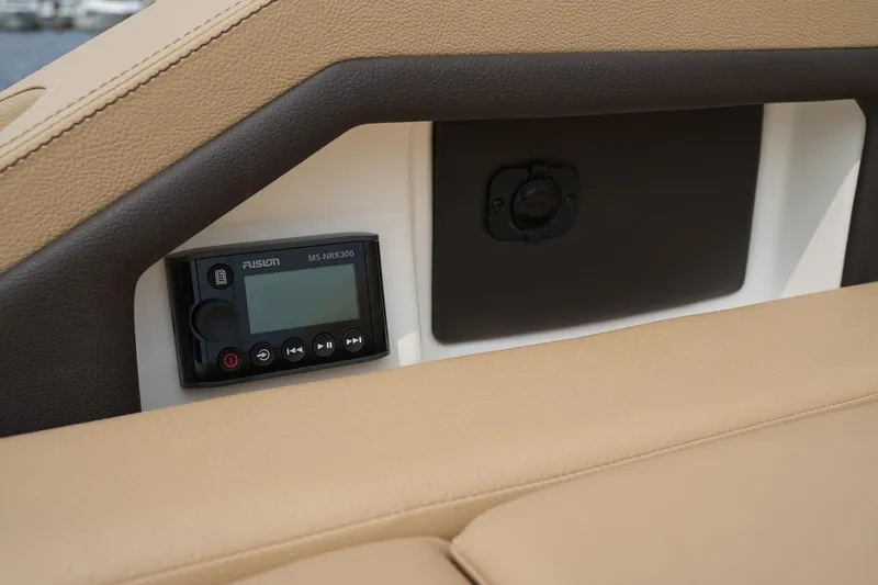 Slide: The Image of 2023 Sea Ray SLX 310 interior with Fusion stereo system and beige upholstery. - 32