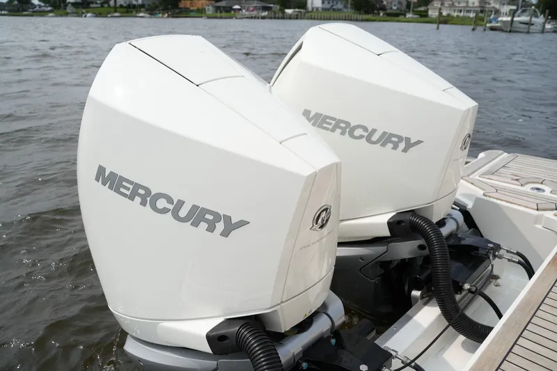 Slide: The Image of Twin Mercury outboard engines on a 2023 Sea Ray SLX 310 boat, docked on a calm lake. - 39