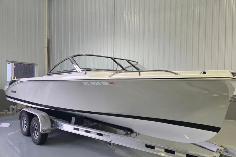 The Image of 2010 Westport 23 Bow Rider Tender on trailer in indoor storage facility. - 0