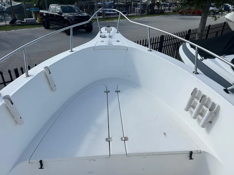 Slide: The Image of 1998 Cobia 224 CC boat deck with rod holders and storage compartments. - 14