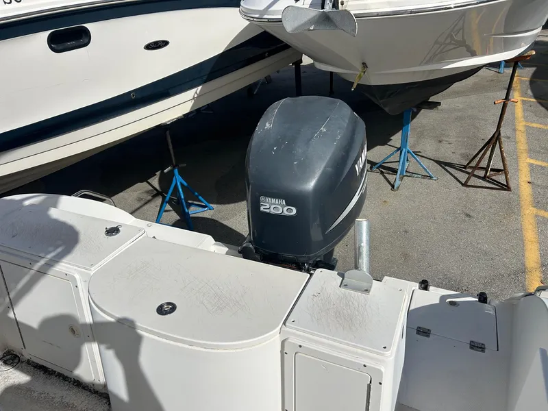Slide: The Image of 1998 Cobia 224 CC boat with Yamaha 200 outboard motor in a marina setting. - 16