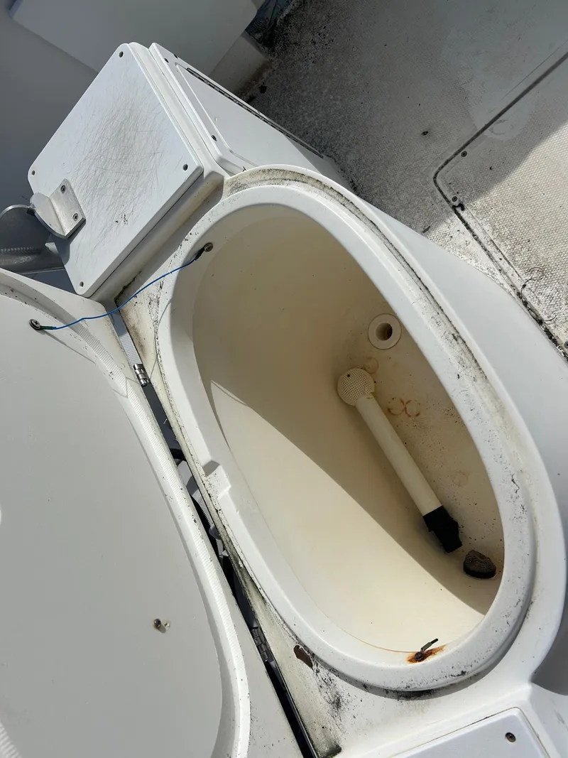 Slide: The Image of Open storage compartment on a 1998 Cobia 224 CC boat, showing interior details. - 17