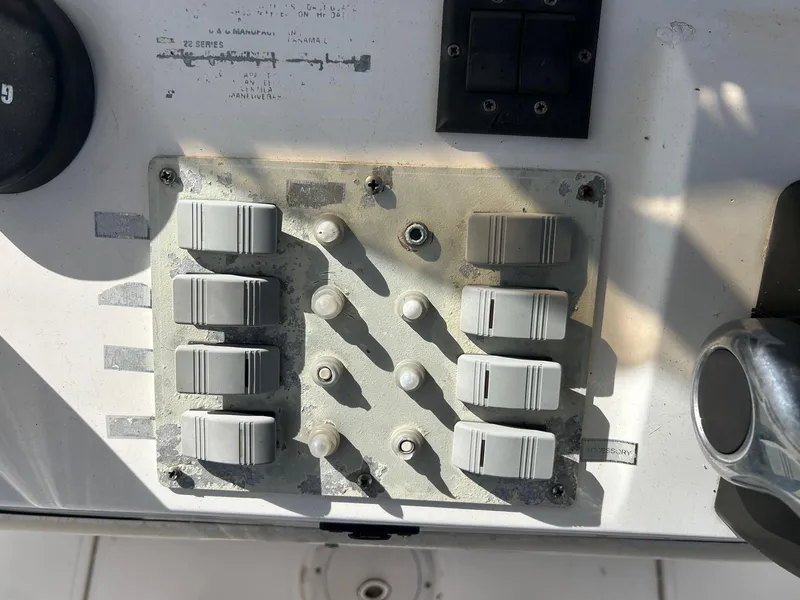 Slide: The Image of Control panel of a 1998 Cobia 224 CC boat with switches and knobs. - 5
