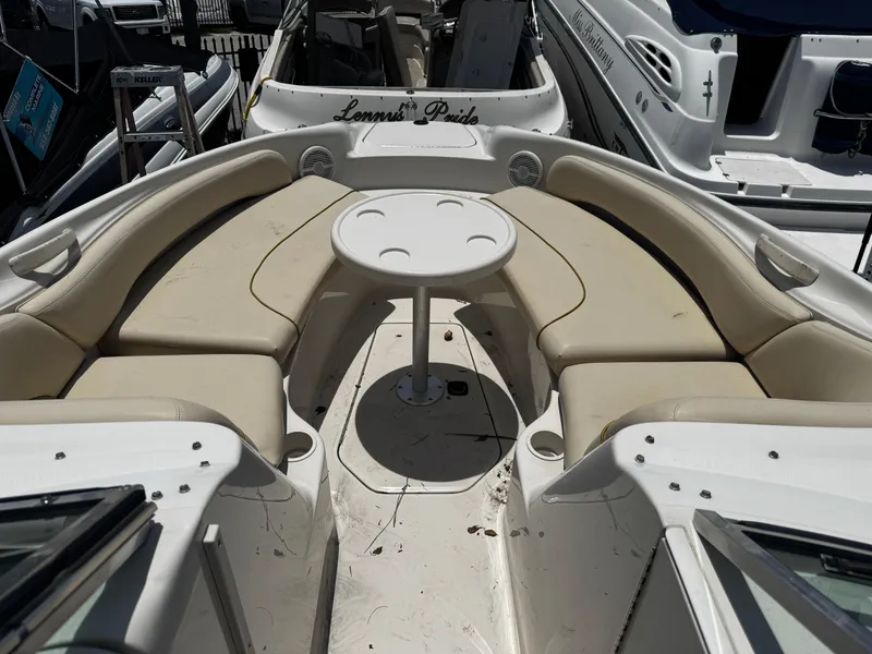 Slide: The Image of 2001 Sea Ray 240 Sundeck boat interior with beige seating and round table. - 3