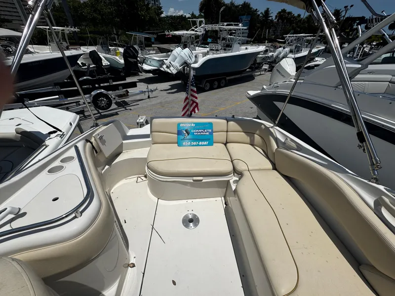 Slide: The Image of 2001 Sea Ray 240 Sundeck boat interior with beige seating, docked among other boats. - 6
