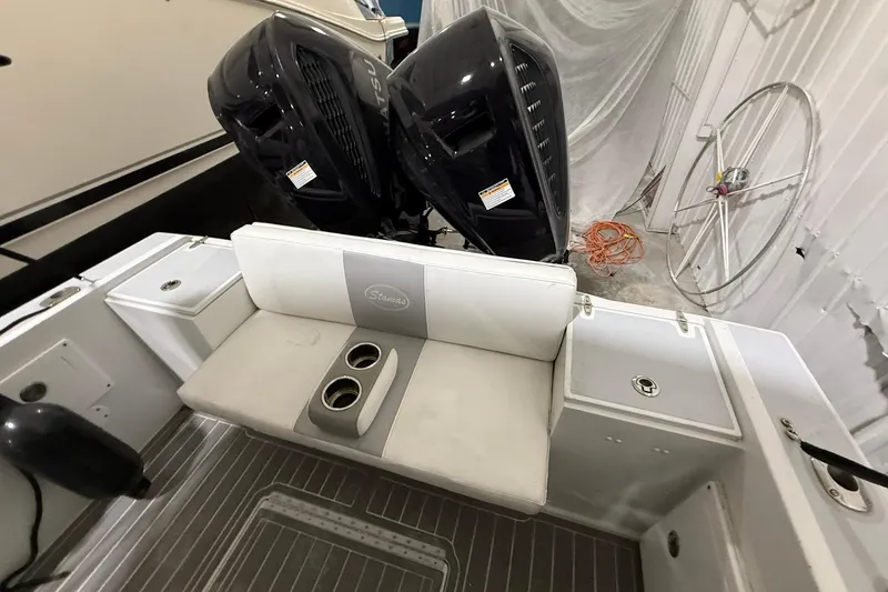 Slide: The Image of 1988 Stamas 255 Tarpon boat interior with dual outboard motors and seating area. - 11