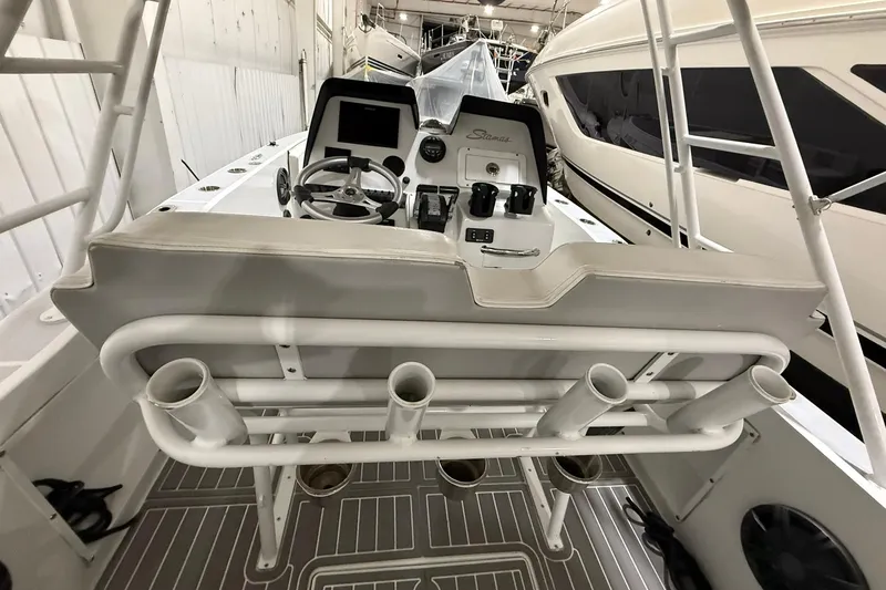 Slide: The Image of 1988 Stamas 255 Tarpon boat cockpit with steering wheel and rod holders. - 12