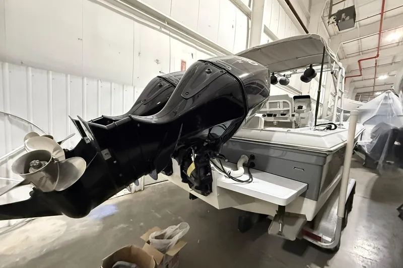 Slide: The Image of 1988 Stamas 255 Tarpon boat with dual outboard motors in a storage facility. - 5